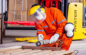 man in orange suit working with cirkular saw