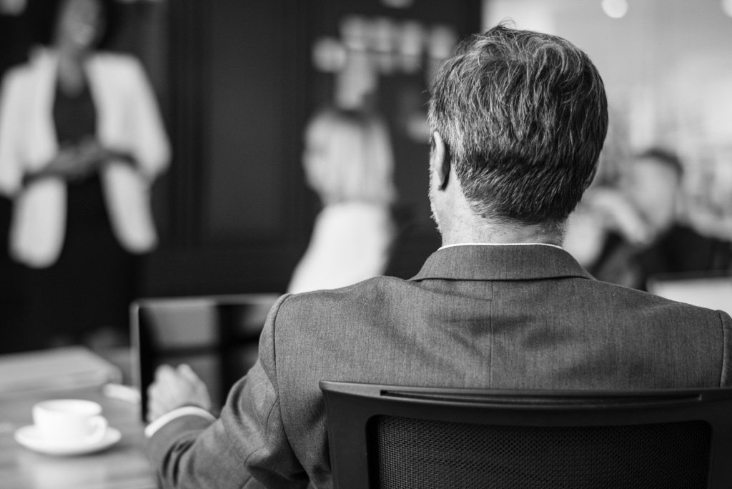 Black white photo of man sitting in cafe with cup of coffee