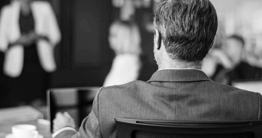 Black white photo of man sitting in cafe with cup of coffee